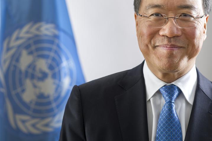 Portrait of Yo-Yo Ma in UN studio with Blue UN flag in back